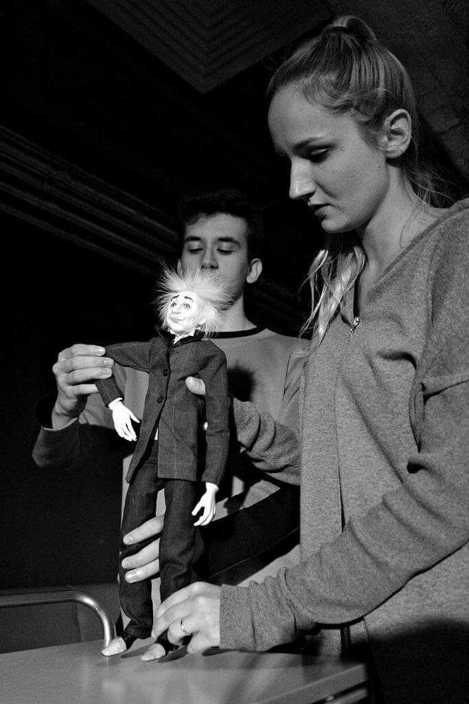 Zdjecie do spektaklu Abecadło. Na zdjęciu dwoje aktorów animuje lalkę - Alberta Einsteina.