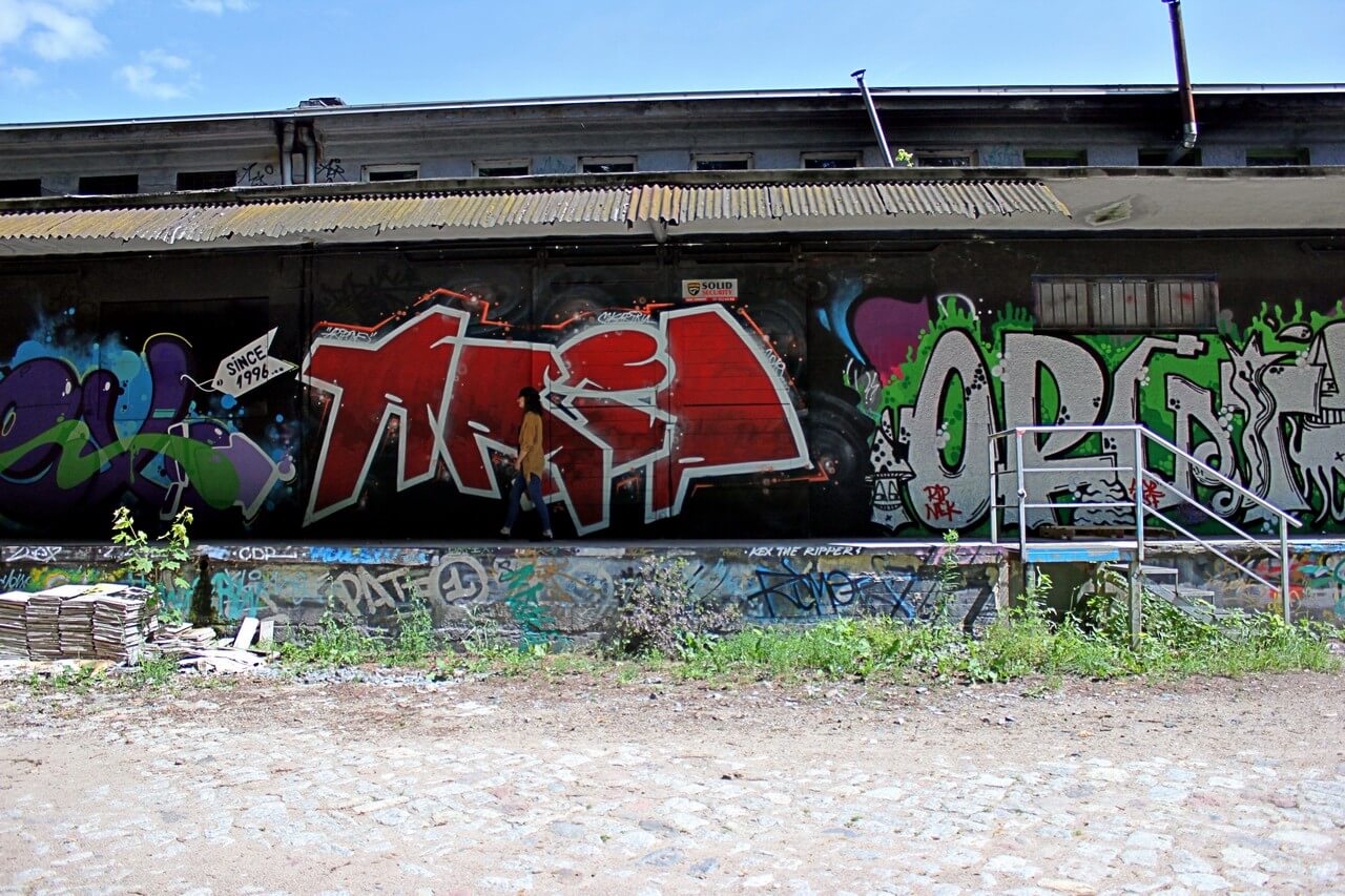 ciąg budynków pokrytych różnokolorowym graffiti